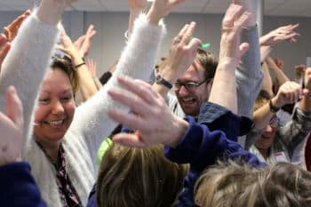 groupe en séance de rire bien-être, yeux souriants et respiration ample