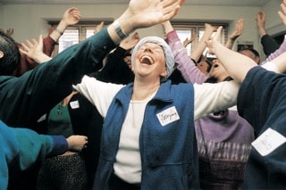 Collègues partageant un moment de rire dans un environnement de bureau, illustrant la cohésion d’équipe et le bien-être en entreprise.