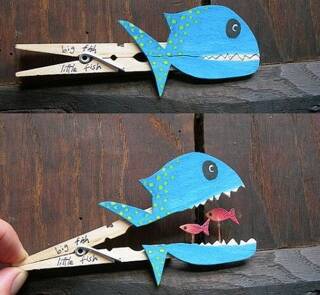 Pince à linge peinte en forme de poisson qui ouvre la bouche pour révéler deux petits poissons, symbole du jeu et de la créativité spontanée.