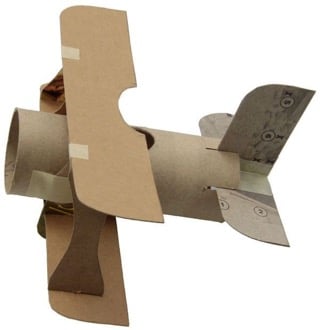 Petit avion bricolé en carton, évoquant la liberté du souffle et la joie simple de créer avec ses mains.