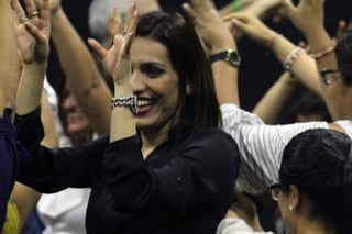 groupe de personnes respirant profondément et levant les bras en rythme dans une séance de rire bien-être, visages détendus et souriants