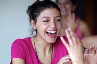 Participants frappant des mains ensemble en rythme lors d’une séance de rire bien-être pour créer une synchronie de groupe