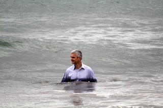 Homme debout dans la mer, chemise mouillée, calme au milieu des vagues — métaphore visuelle du rire qui redonne souffle quand la vie serre trop fort.